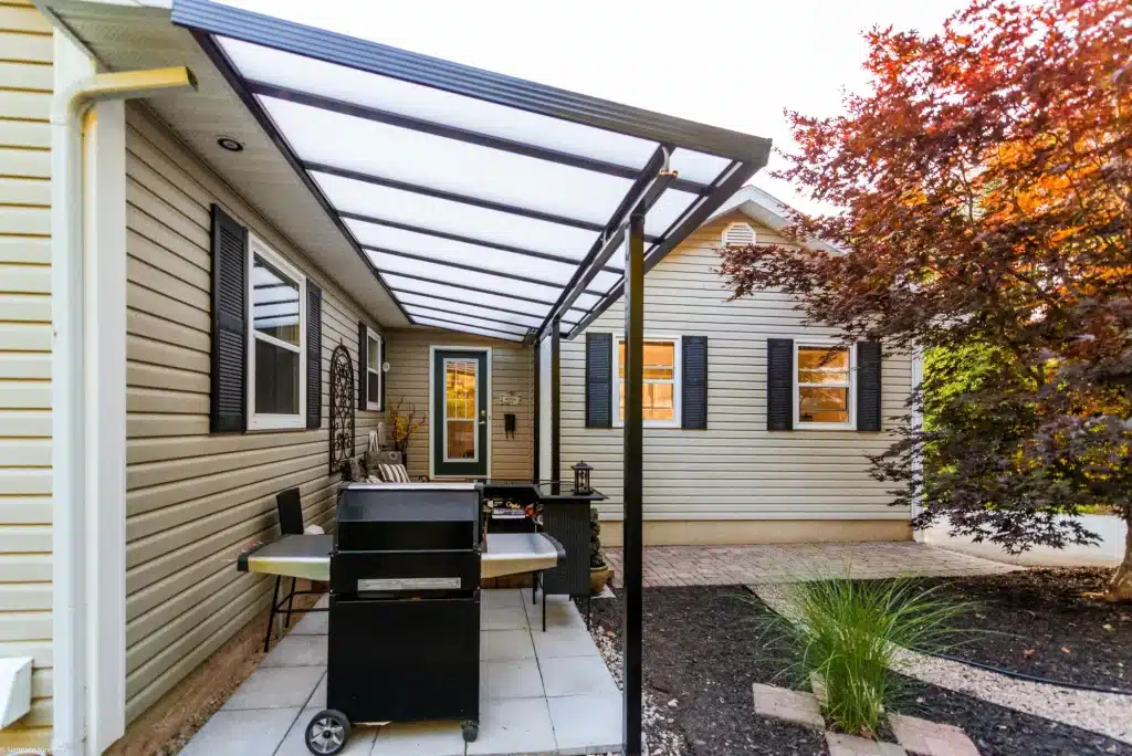 acrylic-patio-cover-in-a-backyard-with-lush-green-scenery-designed-by-sunspace-central-ohio